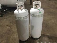 Front view of two white propane cylinders standing side by side