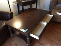 Top view of the coffee table showing the smooth dark wood surface and two open drawers with dove-tailed construction.