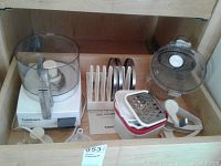 Full view of Cuisinart food processor, disc cutters, cheese graters, and jug in wood drawer.
