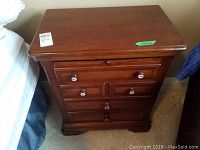 Top view of one nightstand showing wood grain, drawer fronts, and stickers