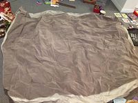 Photo of the inflated air mattress on floor, showing the full surface area, gray/beige color and material.