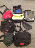 Full view of all seven bags laid out together showing a mix of cooler lunch bags, waist purse, and travel bags in various colors and styles.
