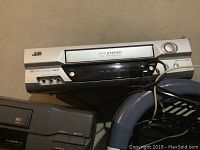 Silver JVC VHS player with stereo and Hi-Fi audio labels, visible front panel controls.