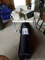 Wheelchair ramp in suitcase-style case on floor with bath seat sitting on top and personal care caddy placed on bath seat.