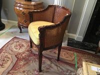 Front left view of wooden cane armchair on rug