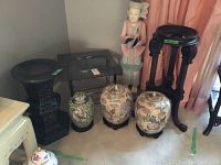 Full lot view showing glass table, plant stand, vase stand, three vases, and a statue figure in the background.