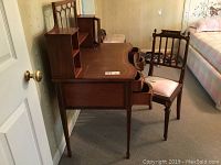 Side view of the wooden desk with chair next to it