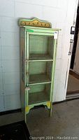 Front view of full cabinet showing three chicken wire panels and door pull.