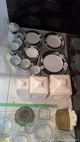 Full set of Mikasa china plates, bowls, cups, saucers arranged with canisters and teapot.