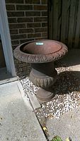 Front view of metal urn showing fluted rim and baluster body