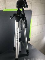 Full view of the silver Soligor T157 tripod with black pan and tilt head and adjustable legs.