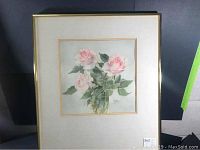 Framed watercolor painting showing three pink roses with green leaves in a clear vase, signed by artist Silvia Clarke.