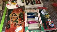 6 vintage Christmas NOMA light ornaments displayed with boxes showing wear and tear