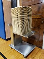 Front view of one stainless steel tray rack loaded with beige plastic trays