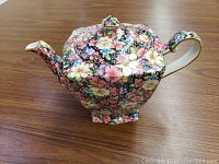 Photo of the Royal Winton Florence teapot showing the floral pattern and shape on a wooden surface.