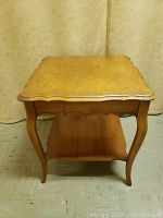 Front view of wood nightstand showing top surface and curved legs