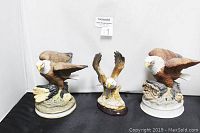 Three porcelain eagle figurines shown together on white background, showing approximate size and details.