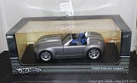 Die cast model car in original packaging showing side profile and box branding.