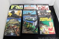 Photo showing 9 PlayStation 2 games in their original cases arranged for display
