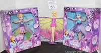 Two fairy figurines in their original purple-themed boxes, each about 8" tall with colorful wings, showing bright packaging and product placement.