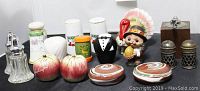 Photo showing 17 vintage salt and pepper shakers and grinders variety including glass, ceramic, metal and wooden pieces in many styles and colors