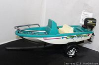 Side angle view of the green and white Nylint Surf Runner toy fishing boat with motor, wheels, and decals visible.