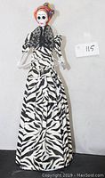 Full view of the Catrina doll showing the black and white patterned dress and overall height.