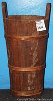 Front view of tall wooden bucket showing two bands and handle extensions above rim.
