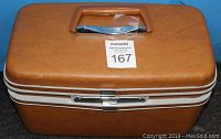Front view of vintage tan Samsonite travel make-up case with handle and two zipper tracks.