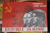 Full view of vintage 1980s Russian propaganda poster showing portraits of Lenin and three men with Russian text and hammer and sickle symbol