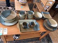 Overview of complete stoneware dinnerware set spread on table