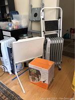 Photo showing Pelonis radiator heater, Polder ladder and Tablemate bed tray with Fiskars garden system box in front.