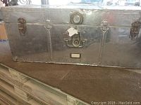 Front view of metal exterior trunk with latch, lock, and label holder