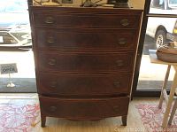 Front view of wood chest of drawers showing four drawers and straight legs.