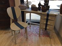 Desk and chair showing front and side angles, highlighting navy blue stripe design and drop-leaf on desk left side