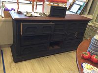 Photo showing the full credenza with wood top and chalk painted base, multiple drawers and cabinet doors, some hardware missing and detached.