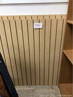 Front view of one wood display rack panel showing vertical slats and grooves for mounting.