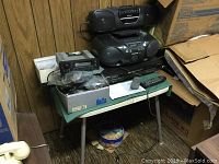 Panasonic and Sony audio and video equipment placed on small table with cables and parts box