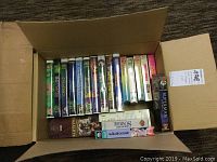 Box open showing various VHS tapes including animated and live-action titles from Warner Brothers and Disney.