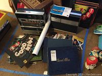 Panoramic view of vintage Panasonic stereo, Longines Symphonette radio, record albums, and other items on the floor