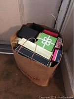 Top-down view of a bag filled with multiple gift boxes of various colors and sizes.