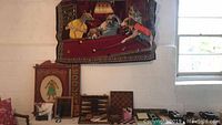 Wide shot of classic games collection including chess, backgammon sets, dominoes, wooden plaque and tapestry on wall