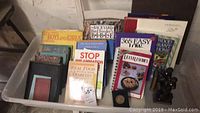 Photo showing multiple books on topics such as diabetes, inflammation, recipes, and more in container.