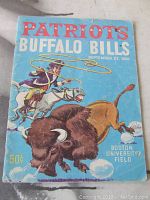 Cover of the football program showing illustrated cover art with patriot on horse chasing buffalo, dated September 23, 1960, with venue Boston University Field and cost 50 cents.