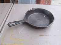 Top and inside view of the cast iron skillet showing three notches on the rim and a smooth cooking surface.
