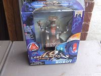 Front view of Lost In Space Battle Ravaged Robot action figure displayed inside original box showing product name and key features.