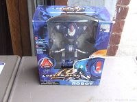 Front view of the vintage Lost in Space Rocket Launcher Robot in its original blue box showing the figure inside and the product name.