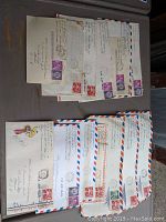 Overview of multiple air mail envelopes stacked, showing postmarks and stamps from early 1960s.
