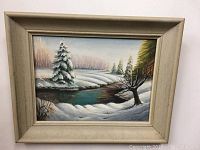 Frontal image showing the full painting and vintage cream-colored frame with snowy winter scene and stream.