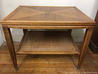 Front view showing rectangular wood side table with geometric patterned top and tapered legs.